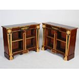 A pair of Regency style mahogany and parcel gilt open bookcases, the shaped rectangular tops with