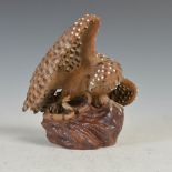 A Chinese Shiwan pottery hawk and snake group, with white glazed details, 18cm high.