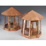 A pair of Arts & Crafts style copper and brass octagonal shaped lanterns, with clear glass