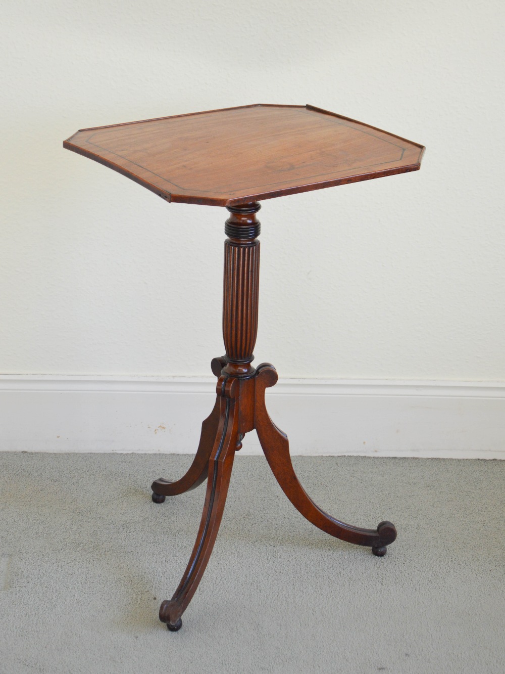 A George III mahogany and ebony lined snap top occasional table, the hinged octagonal top with a