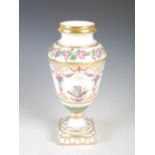 A late 19th century Continental porcelain urn shaped vase, decorated in the Neoclassical style