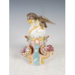 A 19th century pottery bird feeder, with bird and globe surmount above three fish shaped supports,
