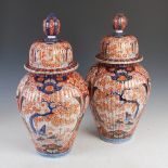 A pair of Japanese porcelain Imari jars and covers, late 19th century, the fluted tapered
