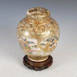 A Japanese Satsuma pottery jar and cover, Meiji Period, decorated with shaped panels enclosing