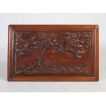 A Chinese dark wood relief carved panel, late 19th/ early 20th century, carved with dragon, waves
