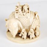 A Japanese ivory okimono of a caparisoned elephant and eleven boys, Meiji Period, signed