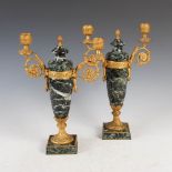 A pair of late 19th/early 20th century ormolu and marble two light candelabra, the mottled black,