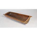 A carved wood apple trough, carved from a single log, with four small carrying handles, 149cm long.