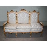 A late 19th/early 20th century gilt wood sofa, the triple panel upholstered back, arms and seat with