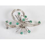 A white metal, emerald and diamond spray brooch, set with ten round faceted emeralds estimated to