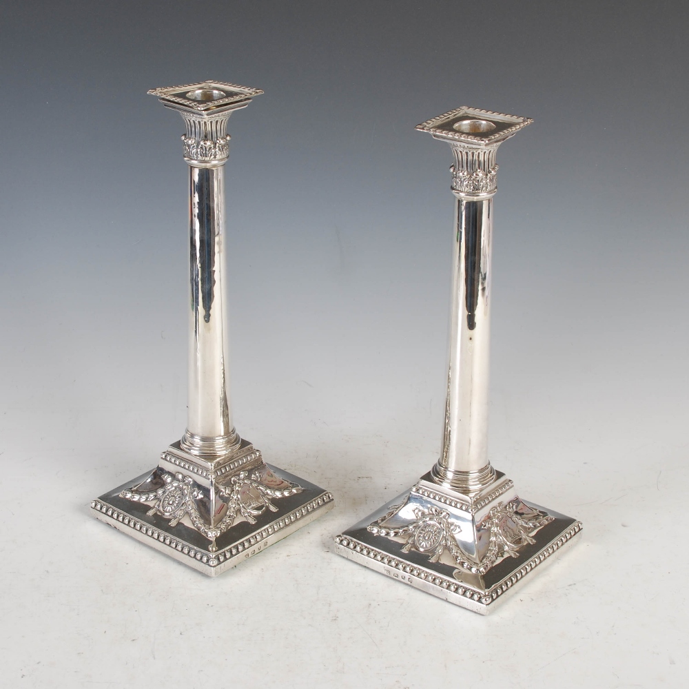 A pair of George III silver Corinthian column silver table candlesticks, London, 1771, makers mark