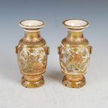 A pair of Japanese pottery twin handled vases, Meiji Period, decorated with panels of Samurai. peony