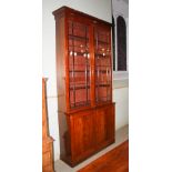 A 19th century mahogany bookcase, the moulded cornice above two astragal glazed cupboard doors