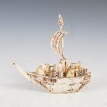 A Japanese ivory okimono of figures in a boat, Meiji Period, with foliate carved and pierced detail,