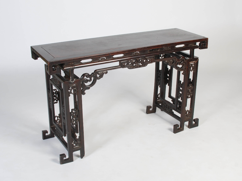 A Chinese dark wood table, late 19th/early 20th century, the rectangular panelled top above a