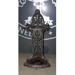 A cast iron corner stick stand, cast with stylised foliate scroll motifs, with detachable drip