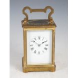 An early 20th century brass cased carriage clock, the black and white enamelled dial with Roman