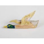 An Edwardian yellow, white metal and enamel brooch in the form of a Mallard duck in flight,