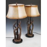 A pair of modern composite stag horn form table lamps and shades, on black circular plinth bases,