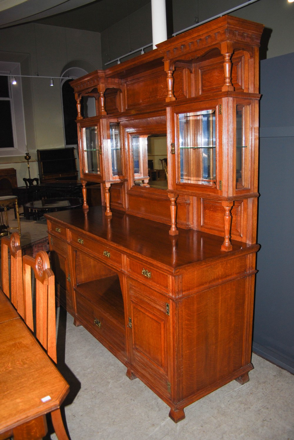 A late 19th century oak dining room room suite, comprising; an extending dining table enclosing four