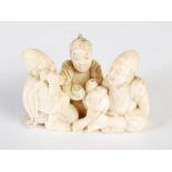 A Japanese ivory okimono figure group of three men, Meiji Period, signed, 4.5cm high x 7cm wide.