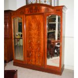An early 20th century mahogany and boxwood lined wardrobe, the arched moulded cornice above a pair