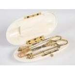 A 19th century French ivory and yellow metal mounted sewing etui, the oval case opening to a