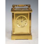 A late 19th/ early 20th century brass repeating carriage clock, the gilt dial with Roman numerals,