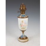 A late 19th century gilt metal and champleve enamel paraffin burning oil lamp, the opaque white