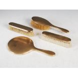 A 9ct gold four piece dressing table set, comprising; handheld mirror, single brush and pair of