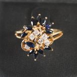 An 18ct gold sapphire and diamond cocktail ring, set with six round brilliant cut diamonds estimated