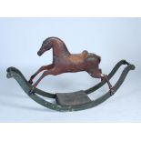 An early 19th century rocking horse, with traces of original bridle, leather saddle and horse hair