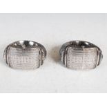 A pair of early 20th century African white metal anklets, hinged and with pin fixing, engraved