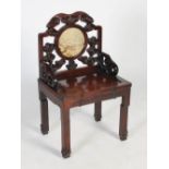 A Chinese hongmu chair, Qing Dynasty, early 19th century, the scroll carved back centred with a