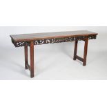 A long Chinese dark wood rectangular table, the panelled rectangular top above a fruit, foliate