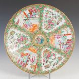 A Chinese porcelain famille rose Canton charger, Qing Dynasty, decorated with panels of figures