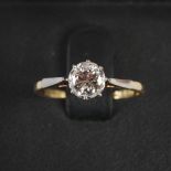 A mid 20th century yellow and white metal solitaire diamond ring, centred with a single round
