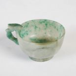 A Chinese green polished stone cup, late 19th century, with naturalistic carved handle, 4.5cm