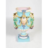 An impressive late 19th century Majolica pottery urn, moulded with three satyr masks, rope twist