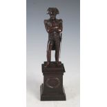 A bronzed spelter figure of Napoleon Bonaparte, modelled standing on square plinth base with oval