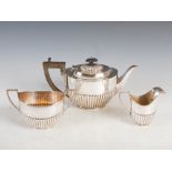 A George VI three piece silver tea set, Birmingham, 1946, makers mark of M.H.&Co., oval shaped