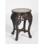 A Chinese dark wood jardiniere stand, Qing Dynasty, the circular top with a round porcelain panel