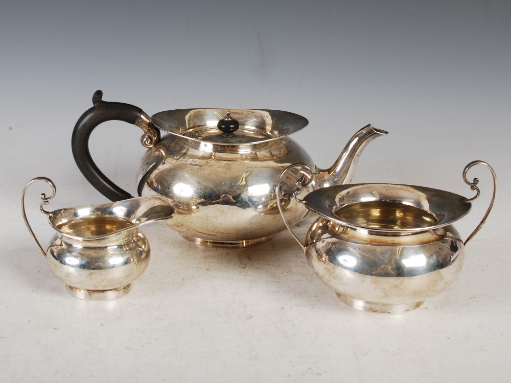 An Edwardian silver three piece tea set, Birmingham, 1908, makers mark of T.W, of plain circular