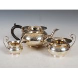 An Edwardian silver three piece tea set, Birmingham, 1908, makers mark of T.W, of plain circular