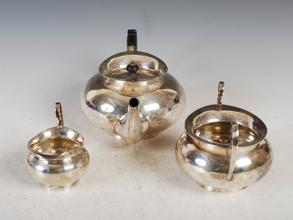 An Edwardian silver three piece tea set, Birmingham, 1908, makers mark of T.W, of plain circular - Image 2 of 16