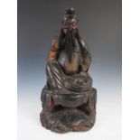 A Chinese carved wood and lacquer figure of an Emperor, Qing Dynasty, carved sitting on a draped