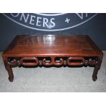A Chinese dark wood Kang table, late Qing Dynasty, the rectangular panel top above a pierced