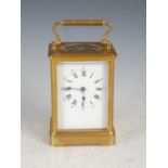 A late 19th century gilt metal carriage clock, the white enamel dial with Arabic and Roman numerals,