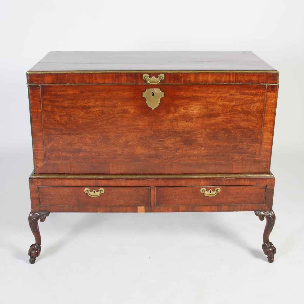 A George III mahogany and brass bound chest on stand, the rectangular chest with brass inlaid