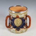 An Edwardian silver mounted Royal Doulton Lord Nelson Commemorative stoneware tyg, the silver mounts